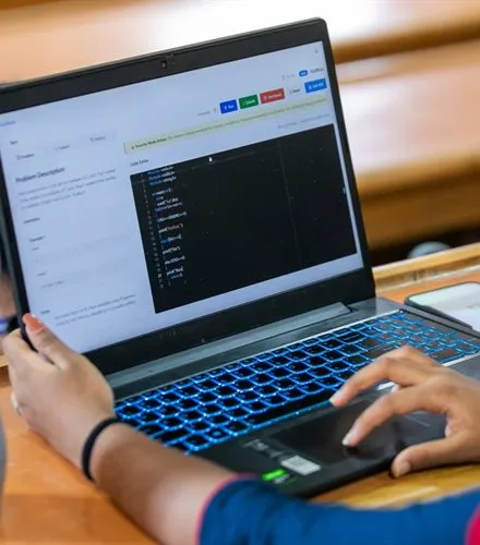Student writing code on a laptop